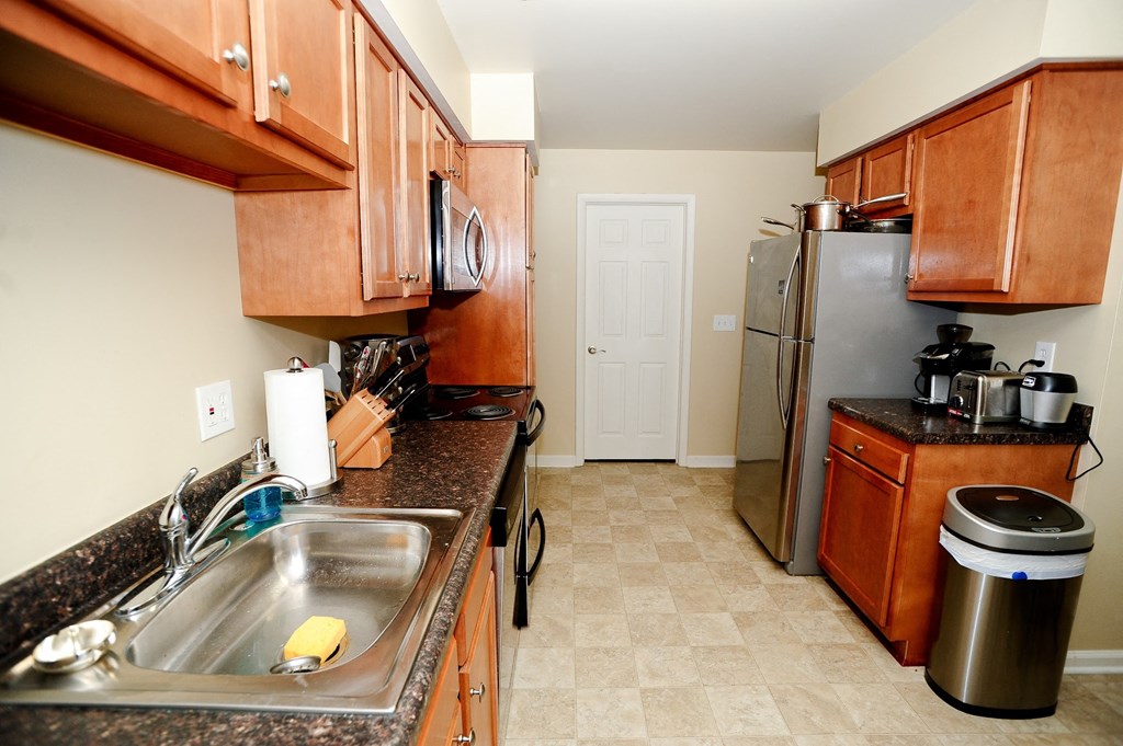 a kitchen with wooden cabinets and a stainless steel refrigerator
