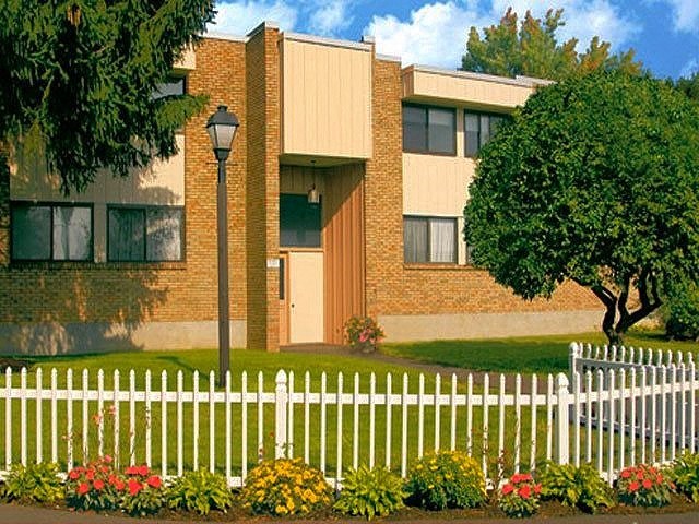 an apartment building with a white fence