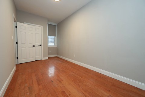a living room with wood floors and a white door