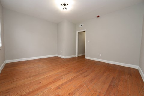 a empty living room with wood floors and white walls