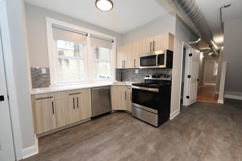 a kitchen with white cabinets and a stove and a window
