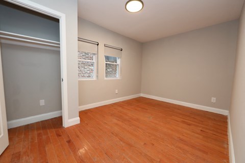 an empty living room with wood floors and a door to a closet