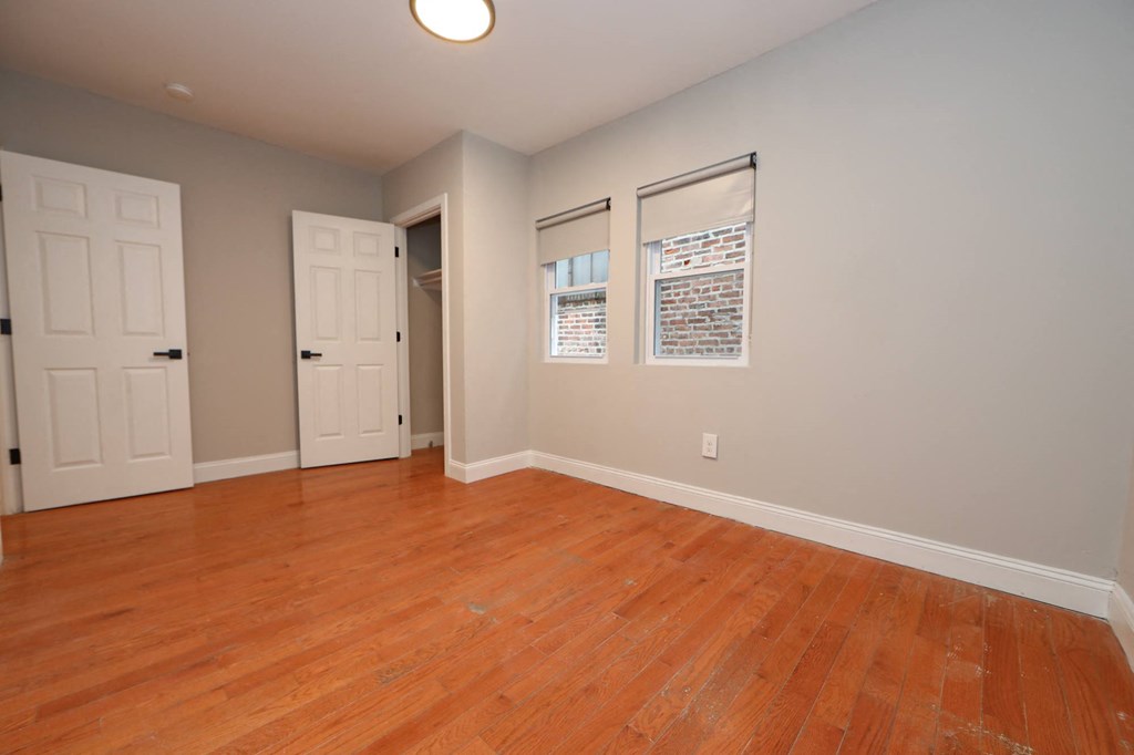 an empty living room with wood floors and white doors