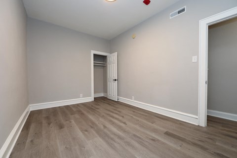 a empty room with wood flooring and a door to a closet
