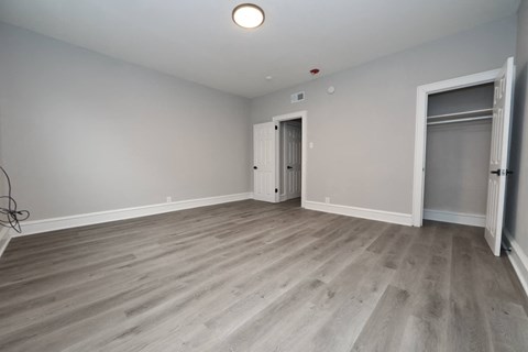 a living room with wood flooring and a door to a closet