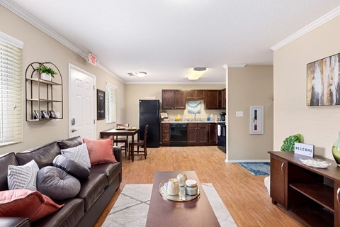 A living room with a brown leather couch and a wooden coffee table.