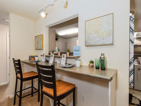 A kitchen with a table and chairs.
