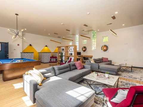 A living room with a pool table and a variety of seating options.