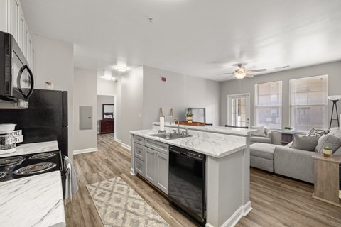 A modern kitchen with a black refrigerator and white countertops.
