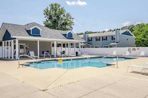 A pool with a slide and a building behind it.