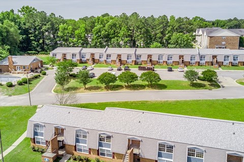 A large building complex with a parking lot in front.