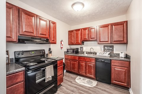 A kitchen with wooden cabinets and black appliances.