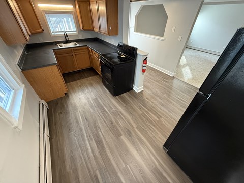A kitchen with wooden cabinets and black appliances.