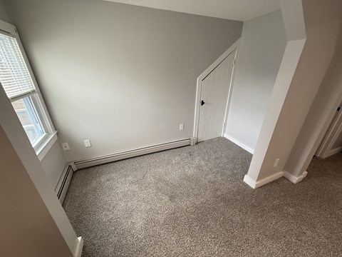 A room with a carpeted floor and a white door.