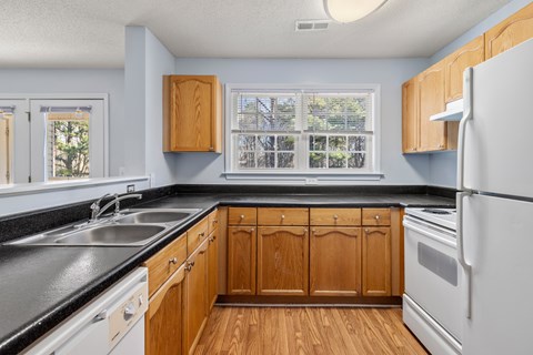 A kitchen with wooden cabinets and a white refrigerator.