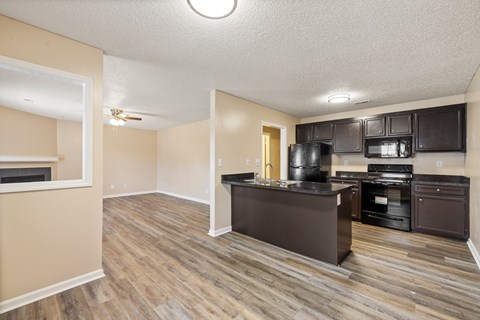 A kitchen with dark wood cabinets and a black countertop.