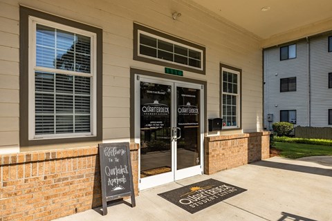 A sign on the front door of a building reads "Welcome to the Quarters.".