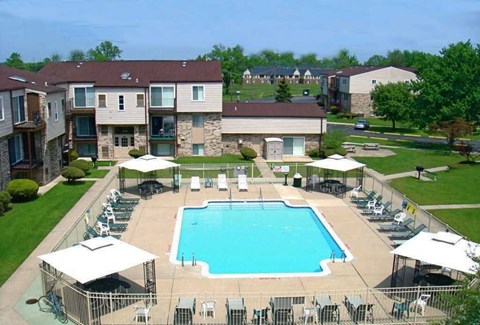 an aerial view of an outdoor pool with chairs and umbrellas