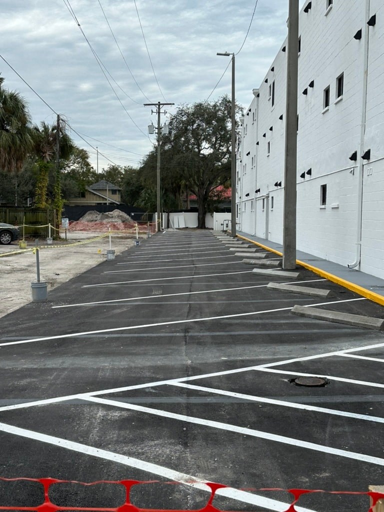 a empty parking lot with a white building on the side