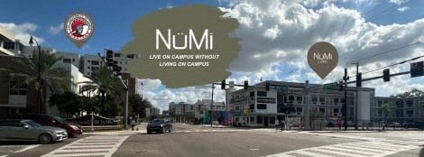 a city street with cars driving on it and a logo and a