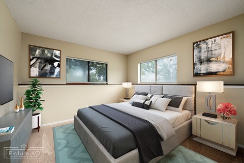A bedroom with a large bed and a potted plant.