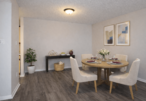A dining room with a round table and chairs.