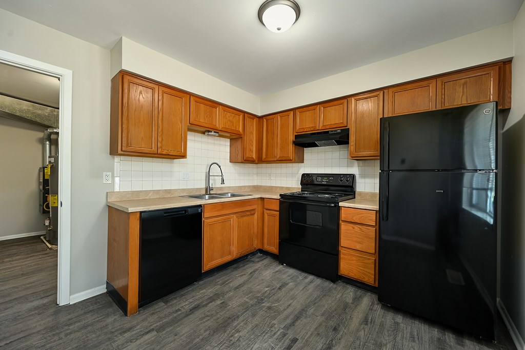 A kitchen with black appliances and wooden cabinets.