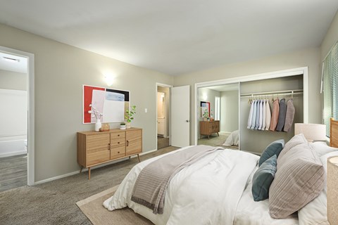 A bedroom with a large bed and a wooden dresser.