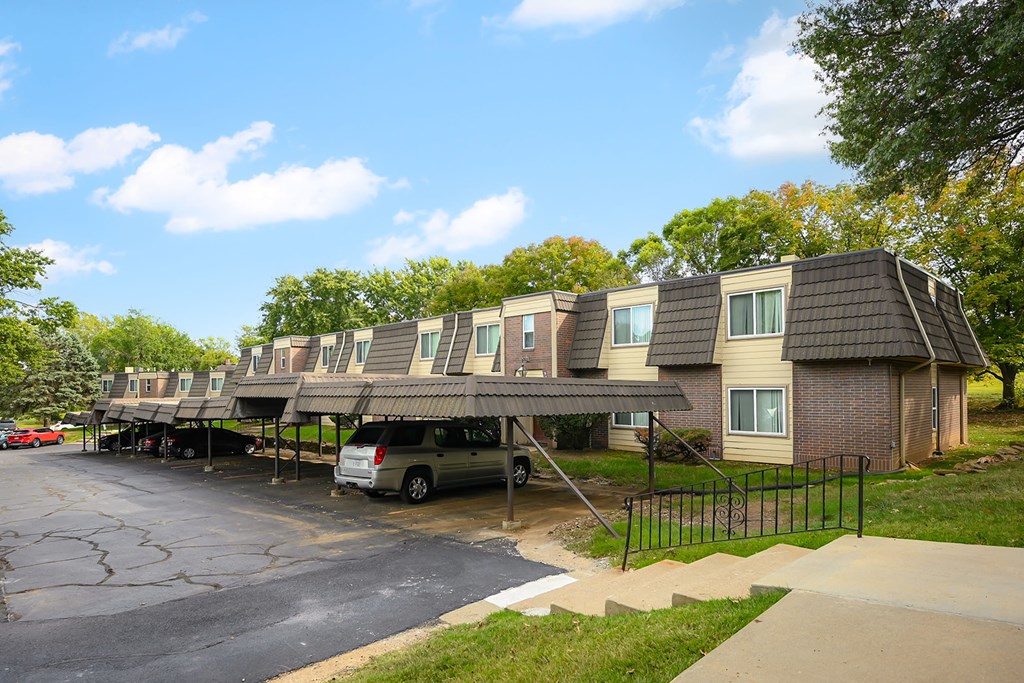 A row of houses with a car parked in front.