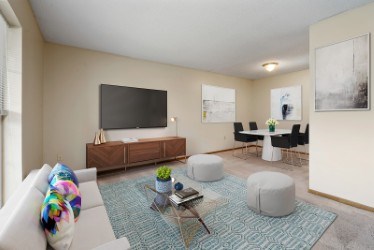 A living room with a white couch and a wooden entertainment center.