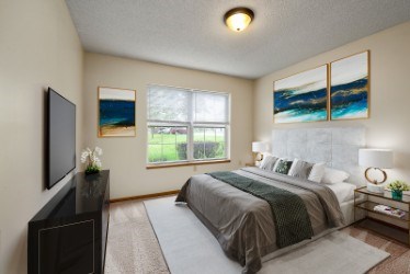 A bedroom with a large bed and a flat screen TV.