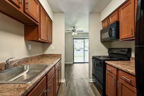A kitchen with wooden cabinets and a black stove top oven.