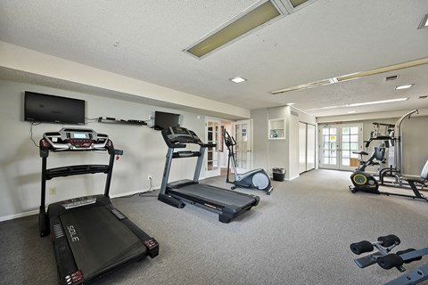 A spacious gym with treadmills, elliptical machines, and other exercise equipment.