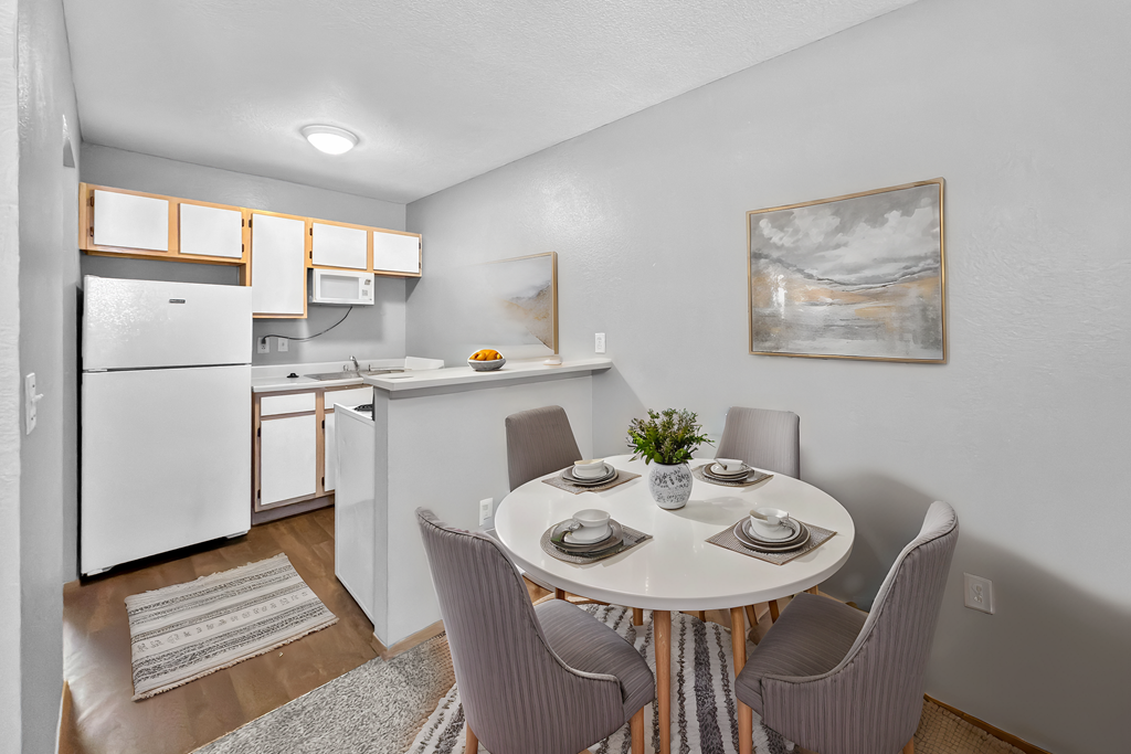 A kitchen with a dining table set for four.