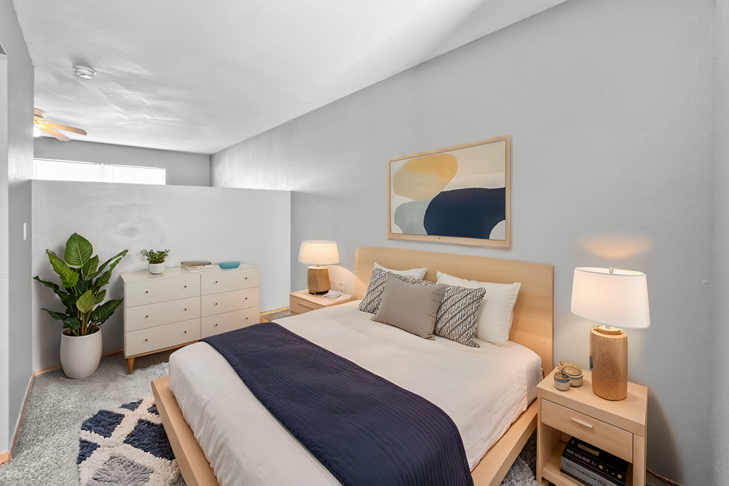 A bedroom with a large bed and a painting on the wall.