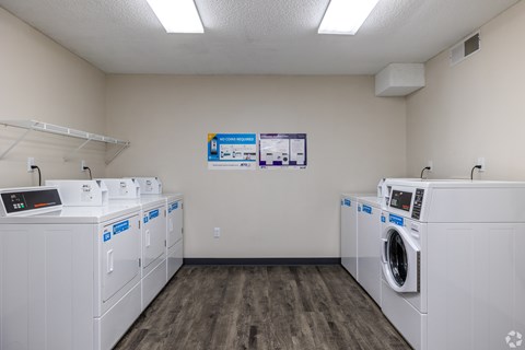 A laundromat with a row of washers and dryers.