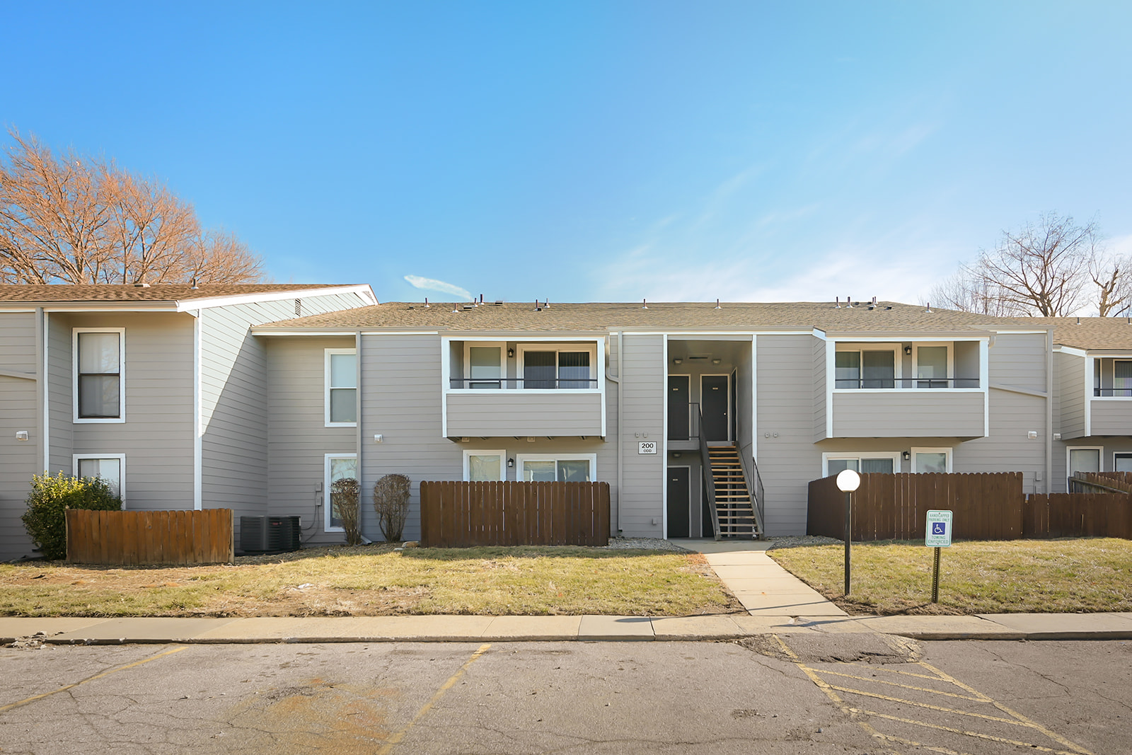 Apartment building with a brown fence in front.