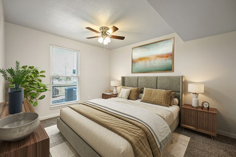 A bedroom with a large bed and a ceiling fan.