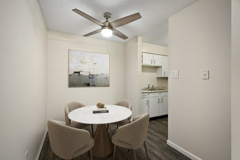 A dining room with a white table and chairs.