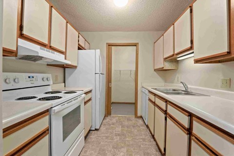 a kitchen with white appliances and wooden cabinets