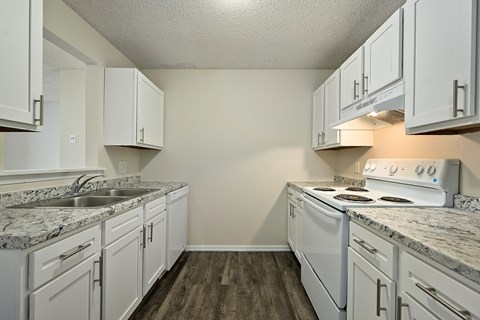 A kitchen with white cabinets and a granite countertop.