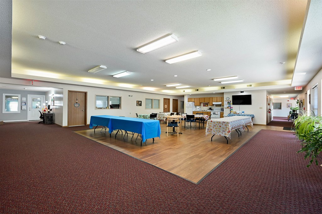 A large room with tables and chairs set up for an event.