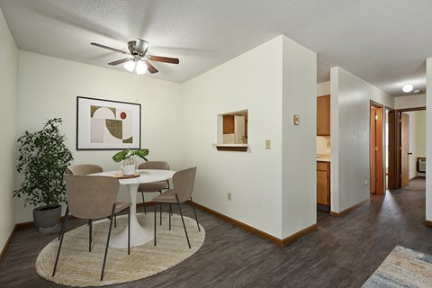 A dining room with a white table and chairs.