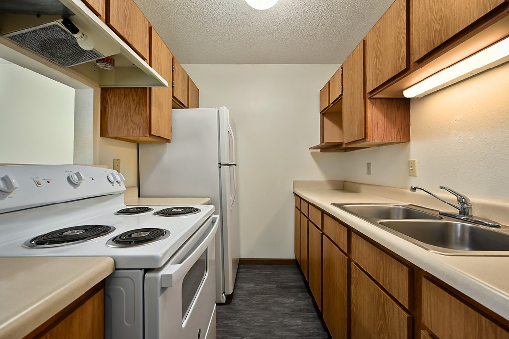 A kitchen with a white stove and a white refrigerator.