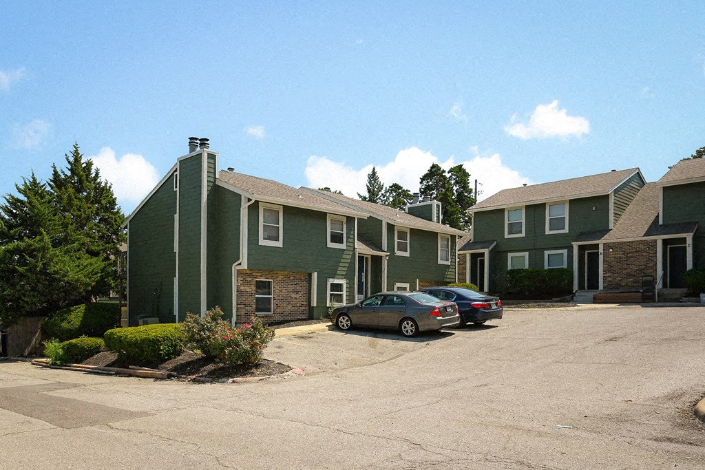 a row of houses with cars parked in a parking lot
