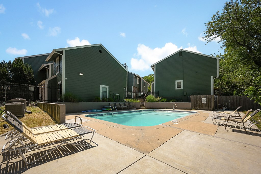 our apartments have a large pool and a patio with chairs