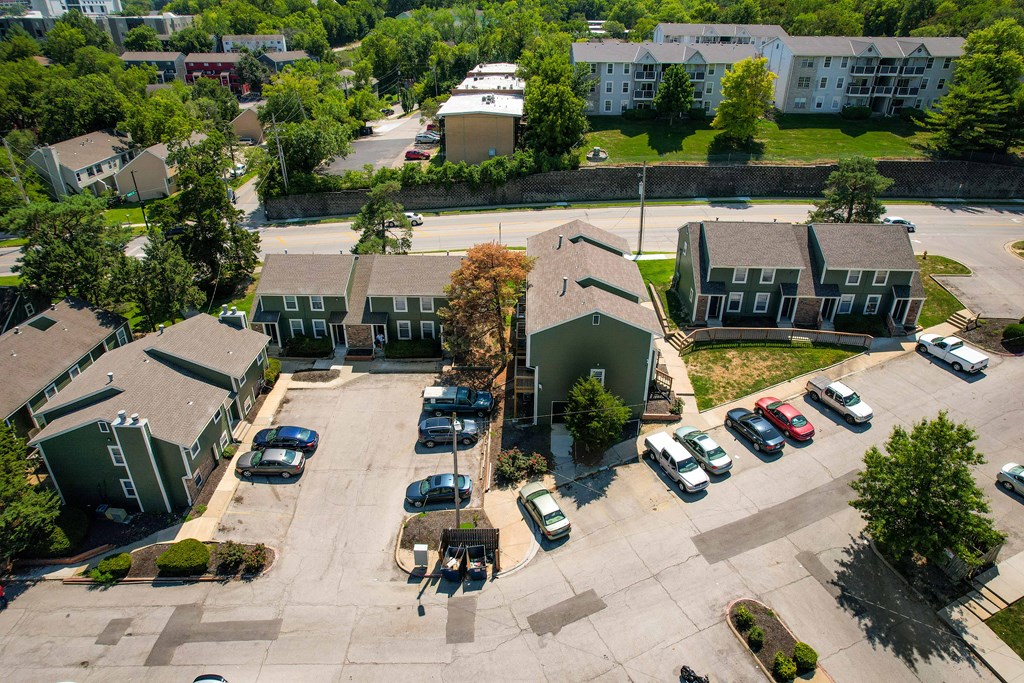 an aerial view of houses and cars in a parking lot