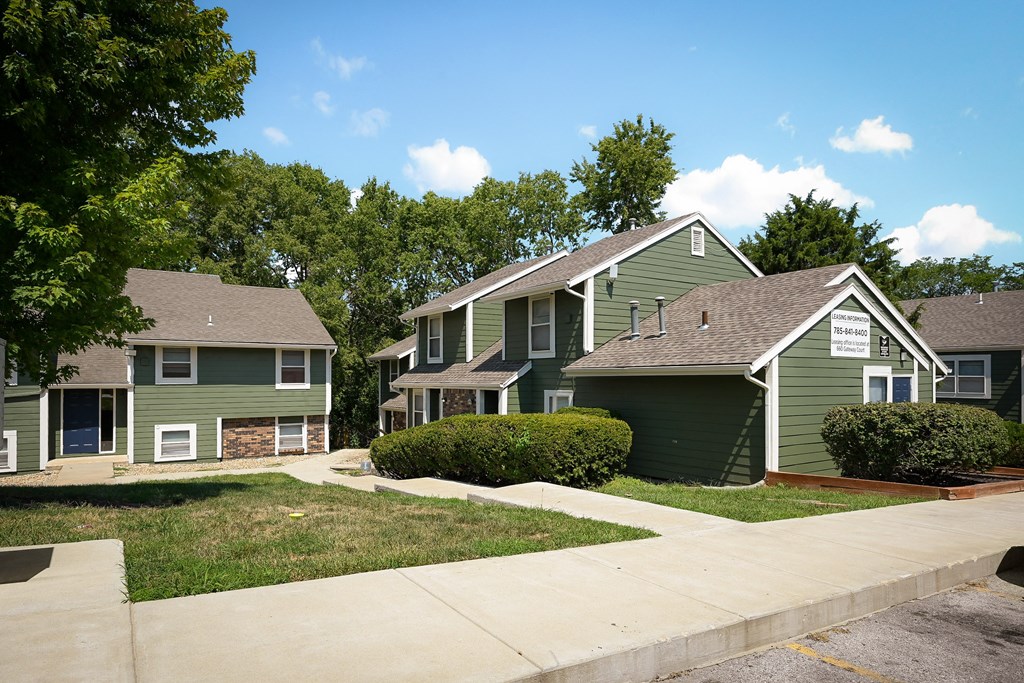 a row of green suburban homes on a sunny day