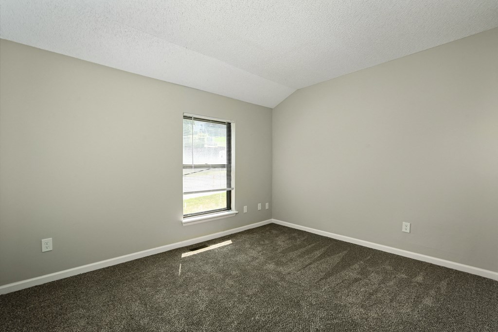 an empty room with carpet and a window