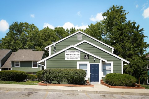 a green house with a sign on the front of it